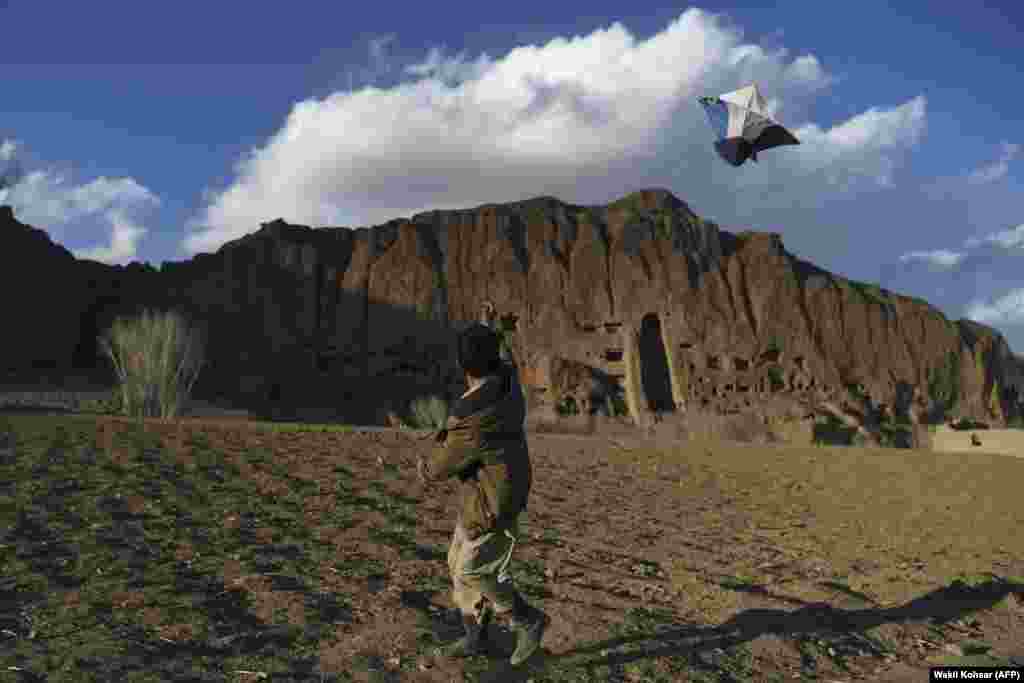 A boy flies a kite near the site of giant Buddha statues, which were destroyed by the Taliban in Afghanistan&#39;s Bamiyan Province in 2001. (AFP/Wahkil Kohsar)