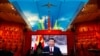 Visitors stand in front of a giant screen displaying Chinese President Xi Jinping next to a flag of the Communist Party of China at the Military Museum of the Chinese People's Revolution in Beijing.