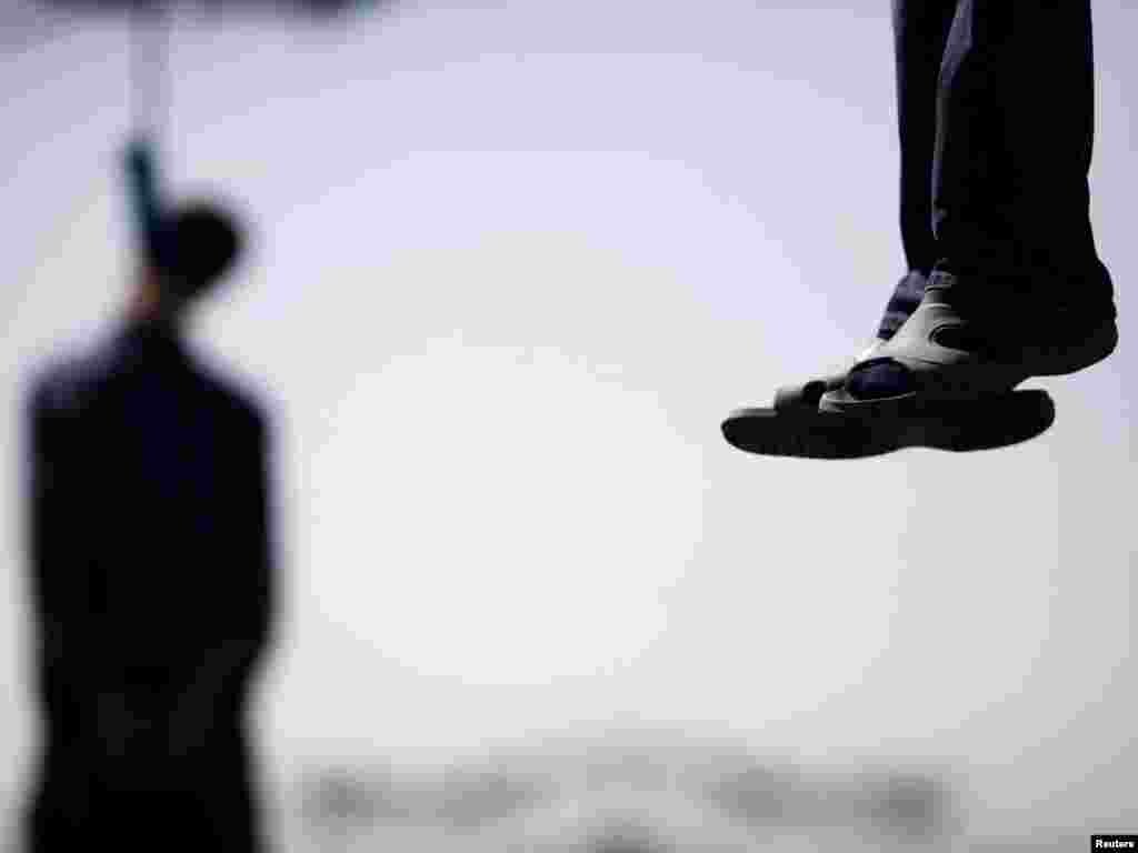 Majid Kavousifar and Hossein Kavousifar, his nephew, hang from the cable of a crane in Tehran August 2, 2007. Iran hanged Majid and Hossein, the killers of a judge who had jailed several reformist dissidents, before a crowd of hundreds of people on Thursday. REUTERS/Morteza Nikoubazl 