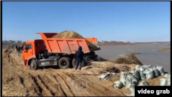 Работы по засыпке берега реки песком в Актюбинской области. Кадр с видео МЧС Казахстана