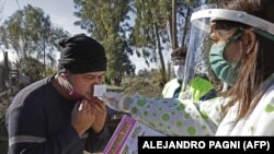 Zdravstvena radnica provodi olfaktorni test - za praćenje gubitka mirisa - u četvrti Altos de San Lorenzo, u blizini grada La Plata u Argentini, maj 2021. 