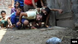 Residents of a border village in the Indian administered Kashmir look at a live mortar shell allegedly fired from the Pakistani side of Himalayan region. 