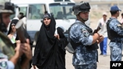 Iraqi police secure a section of the route in Baghdad where pilgrims travel on their way to Karbala.