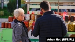 Nafije Ajeti duke bërë pazar me një blerës në tregun mobil në Prishtinë.