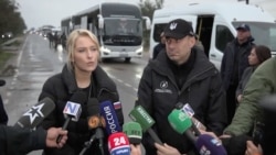Омбудсмени Росії і України Лантратова та Лубінець на тлі автобусів для евакуації людей з окупованих Олешків. 30 жовтня 2026 року