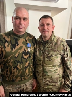 Russian officer Roman Demurchiev, then a colonel, wears a medal that General Ivan Popov (right) has decorated him with, in December 2022.