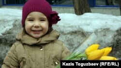 Kazakhstan - Girl with flowers on the eve of International women's day /screen shot/. Almaty, 07Mar2012.