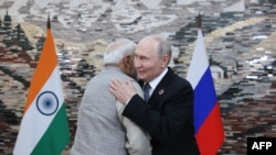 TOPSHOT - Орусиянын президенти Владимир Путин менен Индиянын премьер-министри Нарендра Моди Шанхай кызматташтык уюмунун (ШКУ) саммитинин алкагындагы жолугушууда учурашууда. Сүрөттү Орусиянын мамлекеттик Sputnik агенттиги тараткан.