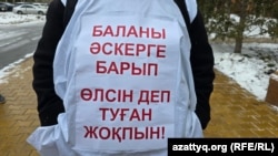 Қазақстан армиясында реформау жүргізуді талап етіп, үкімет үйінің алдына келіп тұрған адамдардың бірі сырт киіміне тағып алған жазу. Астана, 10 қараша, 2025 жыл.
