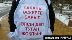 Қазақстан армиясында реформау жүргізуді талап етіп, үкімет үйінің алдына келіп тұрған адамдардың бірі сырт киіміне тағып алған жазу. Астана, 10 қараша, 2025 жыл.