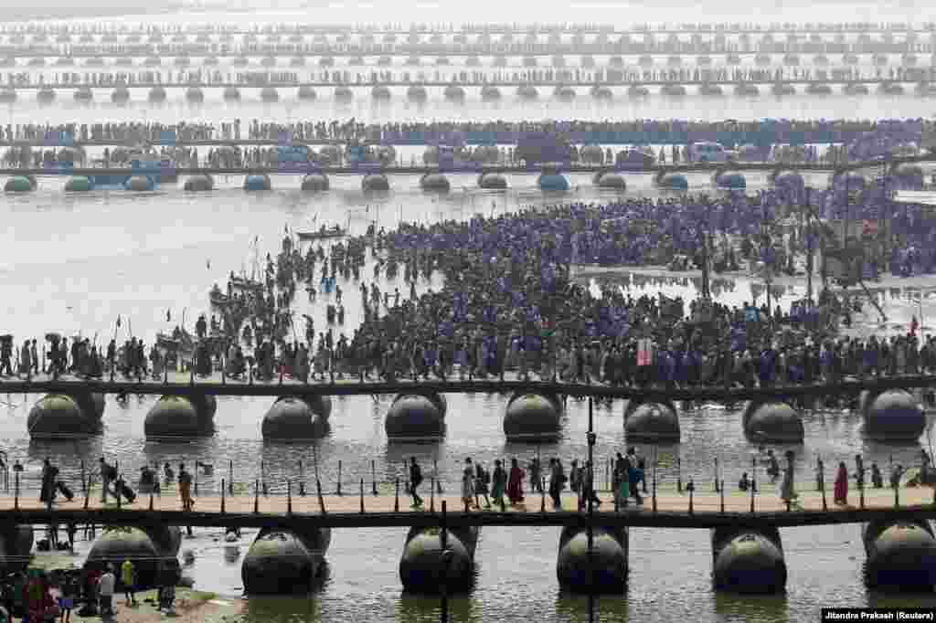 Hindistanlı dindarlar Sanqam sularında çiməndən sonra Qanq çayını keçir 