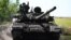 Ukrainian soldiers drive a T-72 tank on the front line in eastern Ukraine in July.