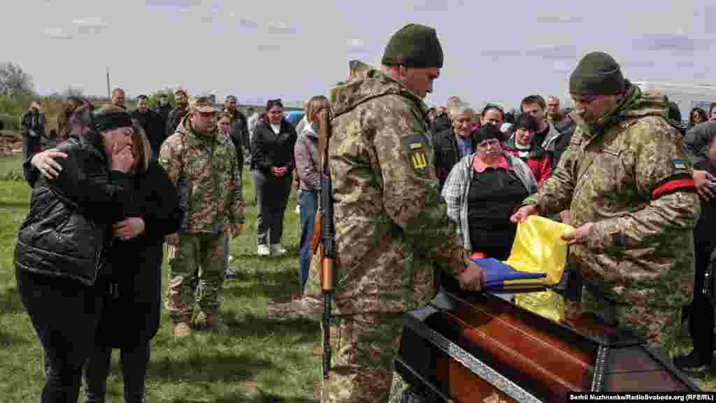 Почесна варта складає прапор України з домовини Олега, його разом із державними нагородами передують родині