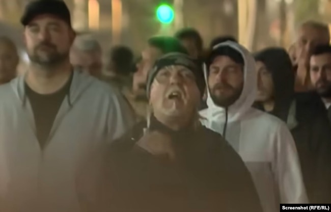 Mes mbështetësve të regjimit të mbledhur para Kuvendit serb ishte edhe Zllatko Novkoviq, një shtetas amerikan dhe rus me origjinë serbe. Me një gjest të dorës mbi qafë, ai u dërgoi një mesazh demonstruesve të mbledhur që protestonin kundër Qeverisë. 2 nëntor 2025.