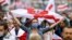 A demonstrator wearing a face mask to protect against coronavirus waves an old Belarusian national flag during an opposition rally to protest the official presidential election results in Minsk on September 27. 