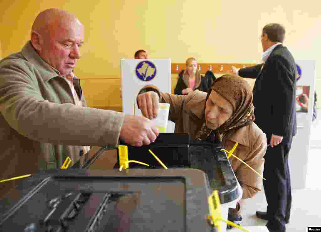 A Kosovar Albanian man and woman vote in Mitrovica.