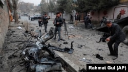 Afghan journalists film at the site of a bombing attack in Kabul on February 20.