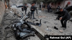 Afghan journalists film at the site of a bombing attack in Kabul in February.