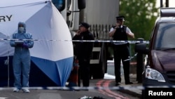 A British police forensics officer investigates a crime scene in which an unarmed soldier was killed in Woolwich, southeast London on May 22. 