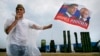 A man holds a flag with portraits of Russian President Vladimir Putin and Prime Minister Dmitry Medvedev in front of S-300 surface-to-air missile systems during a military exhibition outside Moscow in 2014.