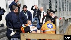 Мэдыкі выносяць параненага зь Мілянскага суду 9 красавіка