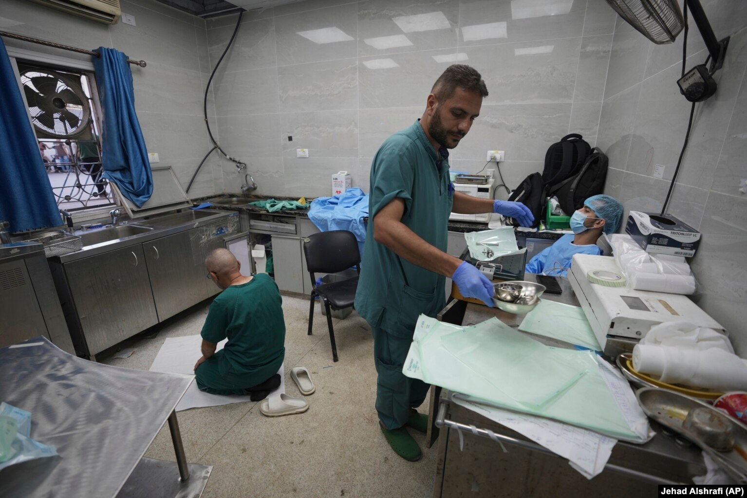 Një pjesëtar i ekipit mjekësor duke u falur në një dhomë për sterilizimin e mjeteve kirurgjike, e cila shërben edhe si dhomë pushimi dhe faljeje për mjekët dhe stafin.
