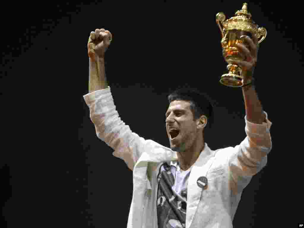 Tennis player Novak Djokovic reacts as he lifts up the Wimbledon men's singles trophy in Belgrade. Djokovic received a rapturous welcome in Serbia following his triumph at Wimbledon and on his first day as the world's top-ranked tennis player.Photo by Marko Drobnjakovic for The AP