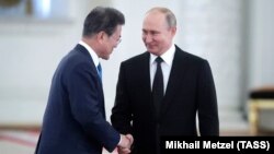 Russian President Vladimir Putin (right) greets South Korean counterpart Moon Jae-in in Moscow on June 22.