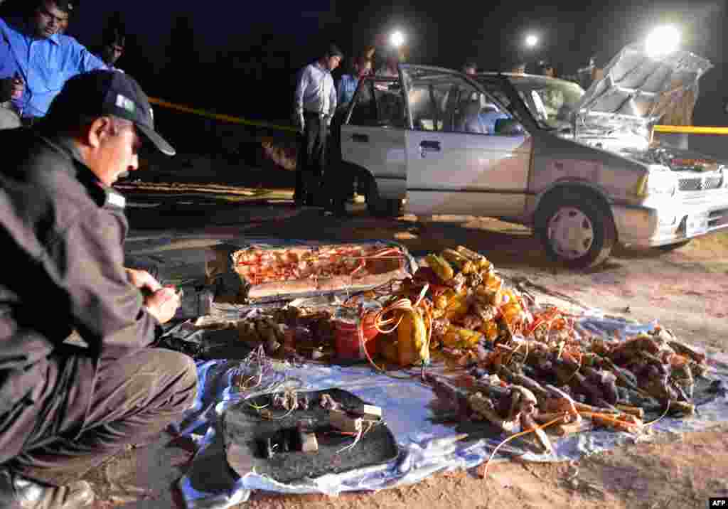 Pakistani security officials search a vehicle found packed with explosives after its seizure by police in the outskirts of Islamabad. The car was found parked on a roadside leading to the villa of former Pakistani military ruler Pervez Musharraf, who is under house arrest. (AFP/Aamir Qureshi)