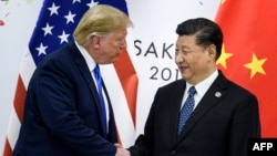 June 28, 2019 shows China's President Xi Jinping (R) shaking hands with US President Donald Trump before a bilateral meeting on the sidelines of the G20 Summit in Osaka