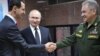 Syrian President Bashar al-Assad (left) greets Russian President Vladimir Putin (center) and Russian Defense Minister Sergei Shoigu at the headquarters of the Russian armed forces in Damascus on January 7, 2020.