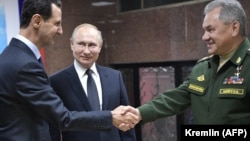 Syrian President Bashar al-Assad (left) greets Russian President Vladimir Putin (center) and Russian Defense Minister Sergei Shoigu at the headquarters of the Russian armed forces in Damascus on January 7, 2020.