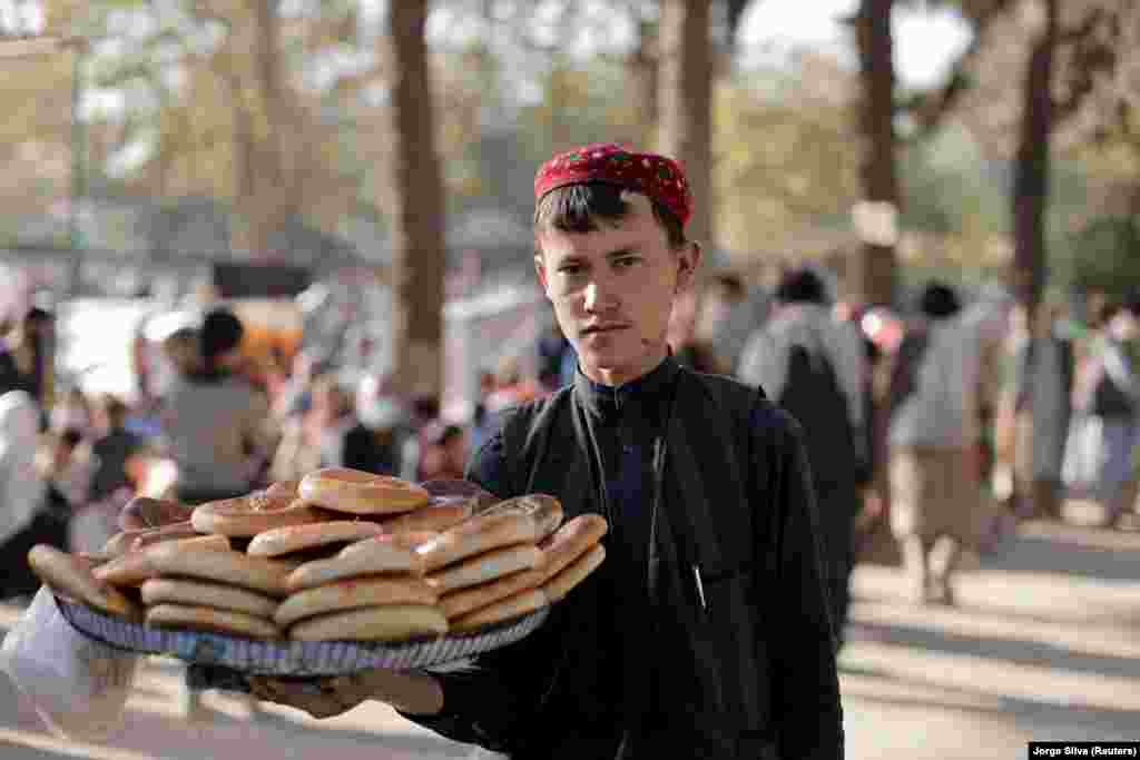 A boy sells bread at a makeshift shelter for displaced Afghan families in the Shahr-e Naw park in Kabul on October 4.