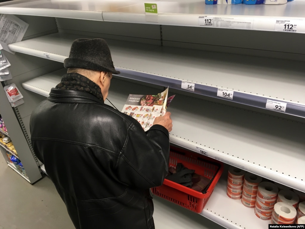 A man stands in front of empty shelves in a supermarket in Moscow on March 17.