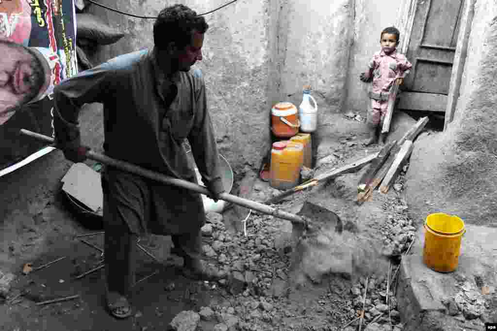 A man removes debris from his home in Jalalabad, Afghanistan.