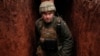 UKRAINE – A Ukrainian service member walks along a trench at a position on the front line near the city of Novoluhanske in the Donetsk region, February 22, 202