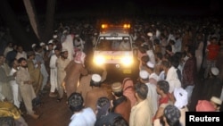 Supporters of Malik Ishaq, chief of the Al-Qaeda-linked Laskhar-e-Jhangvi in the Punjab region, wait for the arrival of his body for burial before his funeral in Rahimyarkhan in southern Punjab Province on July 29.