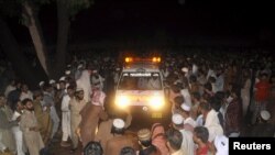 Supporters of Malik Ishaq, chief of the Al-Qaeda-linked Laskhar-e-Jhangvi in the Punjab region, wait for the arrival of his body for burial before his funeral in Rahimyarkhan in southern Punjab Province on July 29.