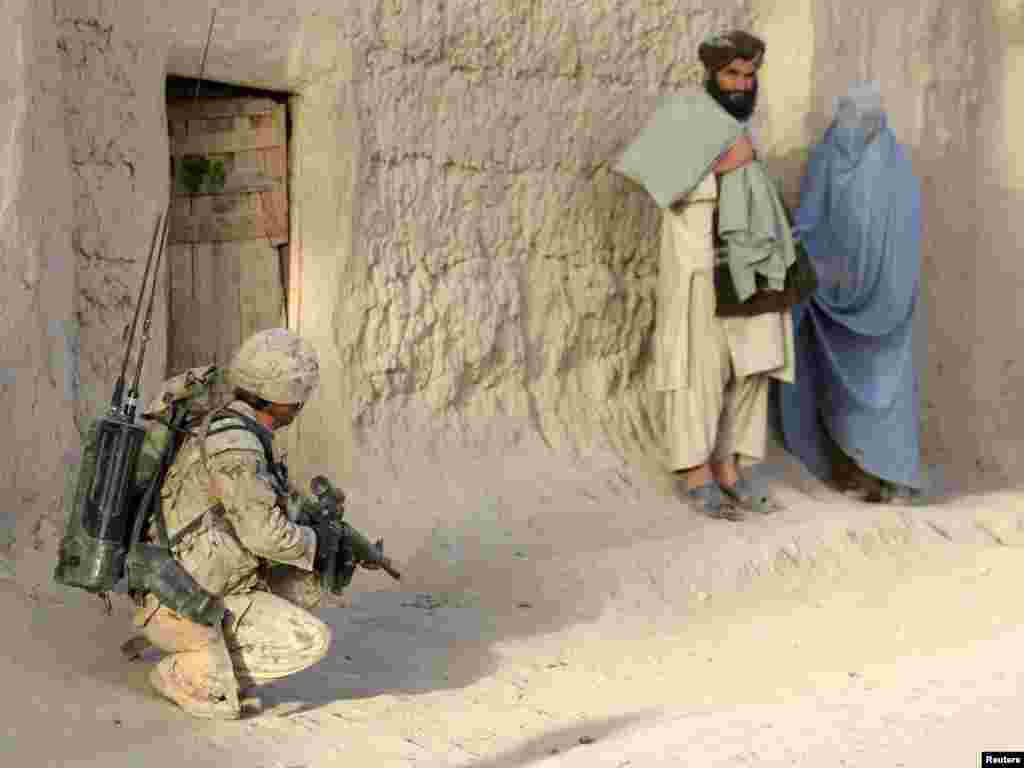 A Canadian soldier secures a street as an Afghan couple looks on during a patrol in the village of Nakhonay in Panjwai district, southern Afghanistan. Photo by Denis Sinyakov (Reuters) 