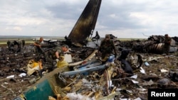Атып түсірілген украиналық Ил-76 әскери ұшағы құлаған жерде жүрген ресейшіл сепаратистер. Луганск, 14 маусым 2014 жыл.