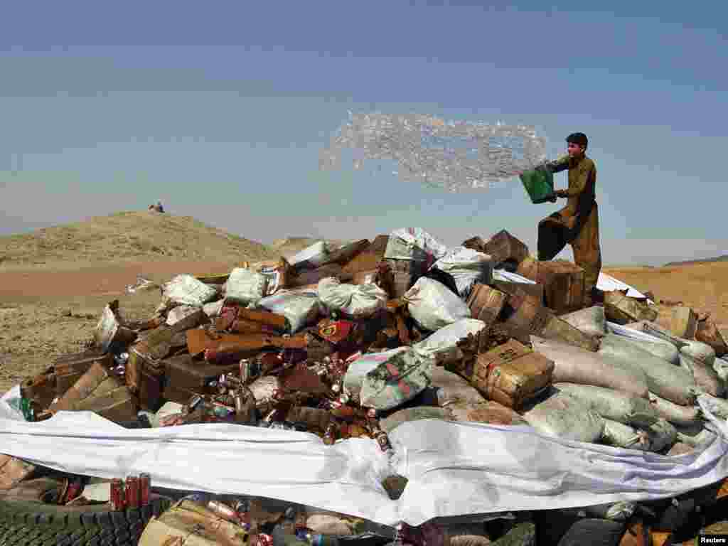 A man pours fuel before setting narcotics on fire in Jalalabad, Afghanistan, on October 12. (Photo by Parwiz for Reuters)