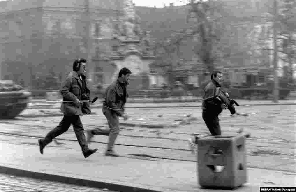 A television crew runs into position in Timisoara during the revolution. After Romanian security services shot many demonstrators dead in Timisoara, a larger demonstration in Bucharest eventually led to the overthrow of the communist regime. Ceausescu and his wife, Elena, were executed on December 25, 1989.