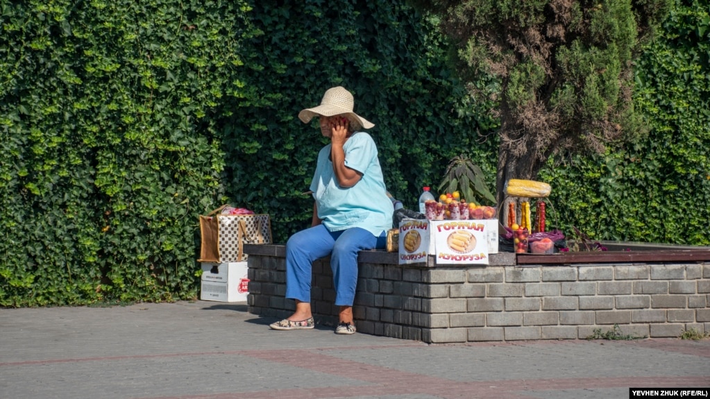 Пожилая женщина торгует алычой, чурчхелой и горячей кукурузой