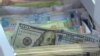 Стодолларовая купюра на фоне других банкнот