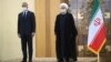 Iranian President Hassan Rohani, right, welcomes Iraqi Prime Minister Mustafa al-Kadhimi as they wear protective face masks to help prevent spread of the coronavirus, during an official arrival ceremony, in Tehran, July 21, 2020