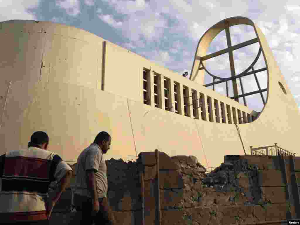 کلیسای کاتولیک «بانوی رستگاری ما» - Residents inspect the site of Sunday's attack that targeted Our Lady of Salvation church in Baghdad, November 1, 2010. At least seven Iraqi Catholics died on Sunday when police stormed the church where gunmen were holding dozens of parishioners hostage, threatening to kill them if al Qaeda prisoners were not released. REUTERS/Mohammed Ameen (IRAQ - Tags: CIVIL UNREST RELIGION)