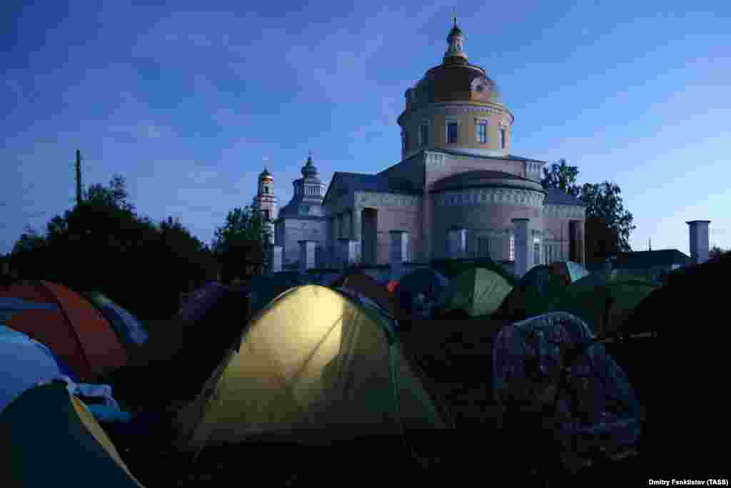 Pilgrims set up tents by St. Nicholas&#39; Church in the village of Velikoretskoye.