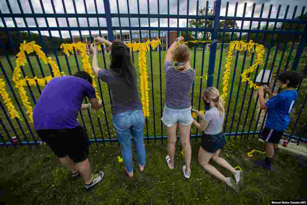 U.S. -- Teachers from Capital City Public Charter School in Northwest Washington, and others decorate their school fence with yellow paper to spell the words Black Lives Matter, Thursday, June 18, 2020,