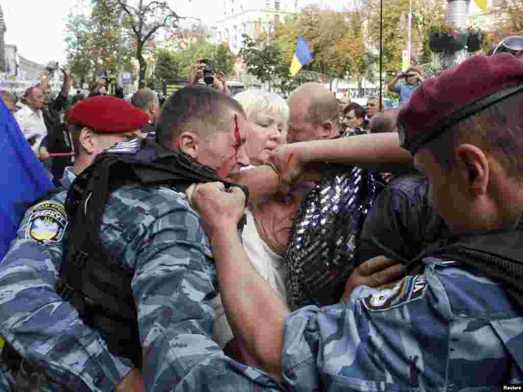 Ofițeri de poliție împiedicînd sprijinitorii fostului premier Yulia Tymoșenko de a demosntra în fața tribunalului de la Kiev unde este judecată. Photo by Vladimir Sindeyev for Reuters