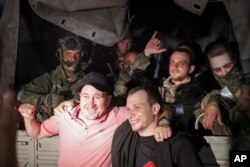 Двама мъже позират за снимки с бойци от "Вагнер", изтеглящи се от Ростов на Дон